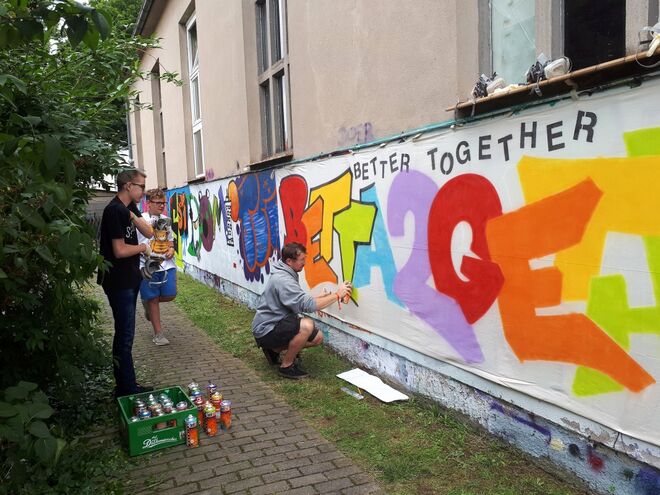 Der Graffiti- Künstler Carsten Langner von Farbclang gestaltete mit einer Gruppe eifriger Jugendlicher ein großes Banner, welches jetzt das Schulhaus schmückt.