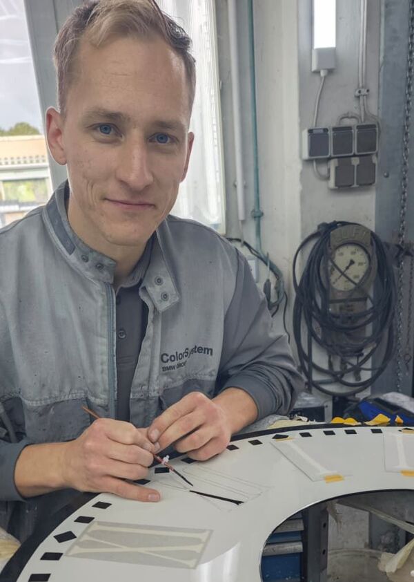 Fahrzeuglackiermeister Benedikt Beyer beim letzten Arbeitsschritt am Ziffernblatt.
