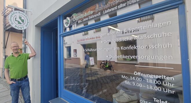 Meister Jens Behrendt verweist auf das Innungszeichen, das seit einigen Tagen werbesatzungskonform als Ausleger den Weg zu seinem Laden weist.