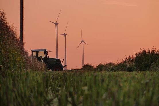Traktor zwischen Windrädern. Symbolbild, (c) Magnific